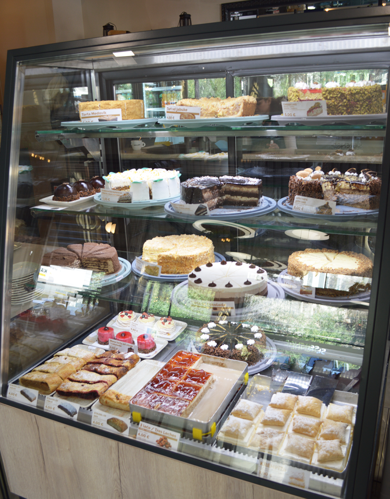 Cake display at Bistro Serenada in Dubrovnik featuring a selection of freshly made desserts including layered cakes, cheesecakes, and pastries arranged in a modern glass dessert showcase, popular cake shop for tourists seeking sweets in Dubrovnik Croatia.