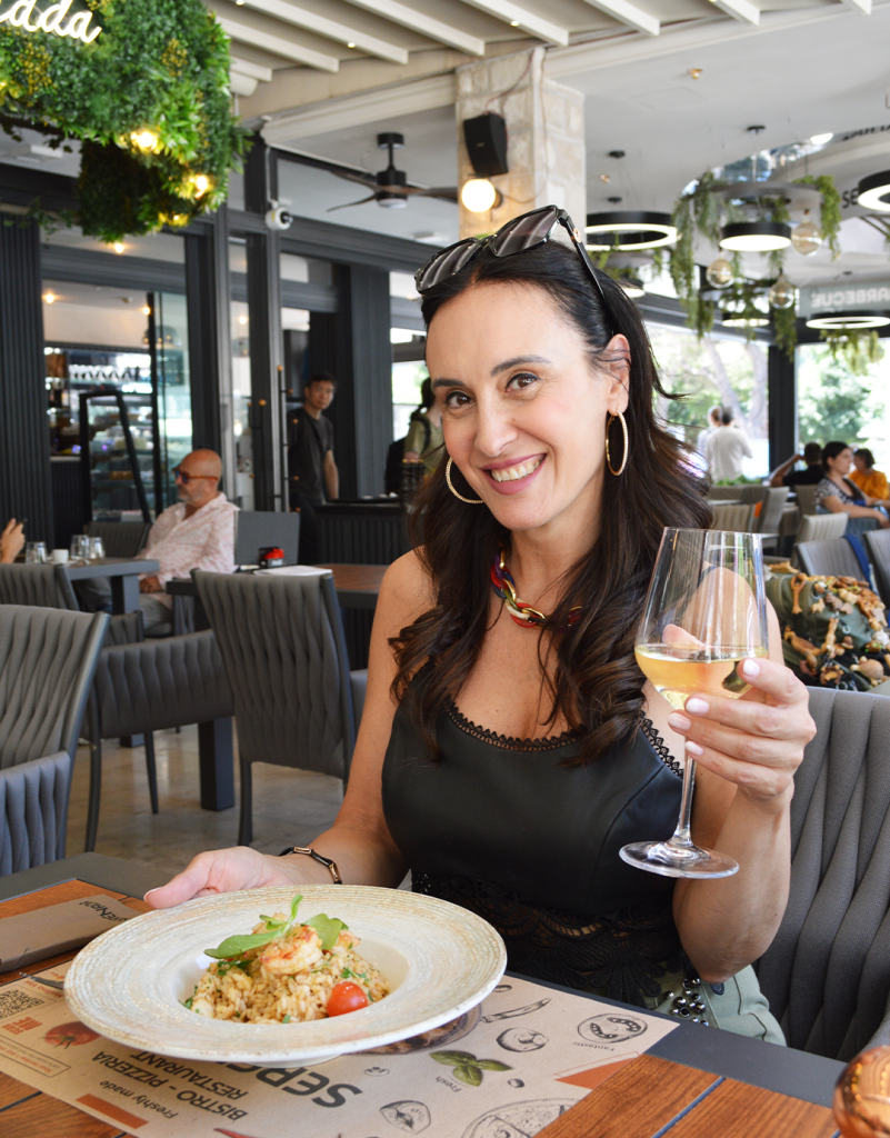 Guest enjoying shrimp risotto with a glass of white wine at Serenada Bistro in Dubrovnik - perfect lunch or dinner in Dubrovnik featurinf Mediterranean cuisine and one of the best restaurants in Dubrovnik. Croatia.